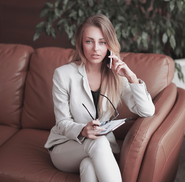 Close upbusiness woman with clipboard talking on the phone