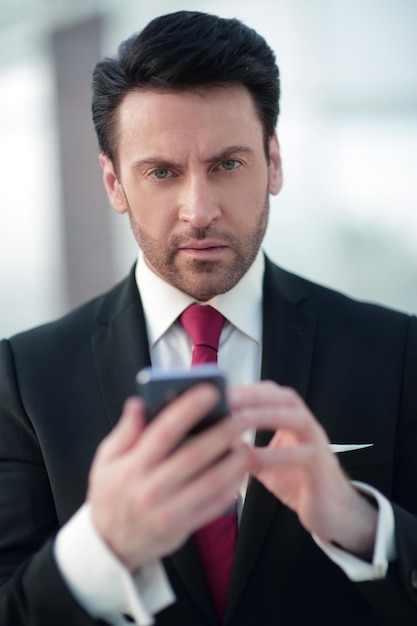 사업가가 스마트폰에 SMS를 입력하고 있습니다.사람과 기술
