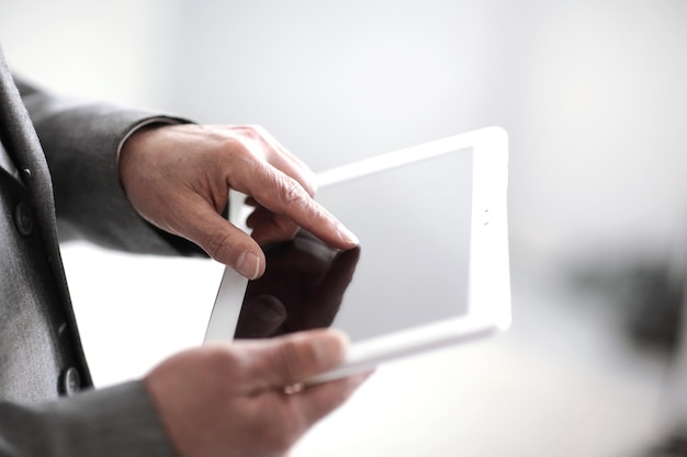 Close upbusinessman presses on the screen of a digital tabletp