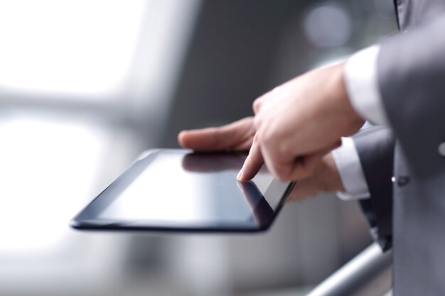 Close upbusinessman pressing finger on digital tablet screen