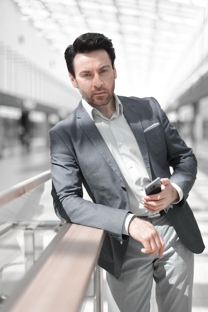 Close upbusinessman reading SMS standing in the airport building