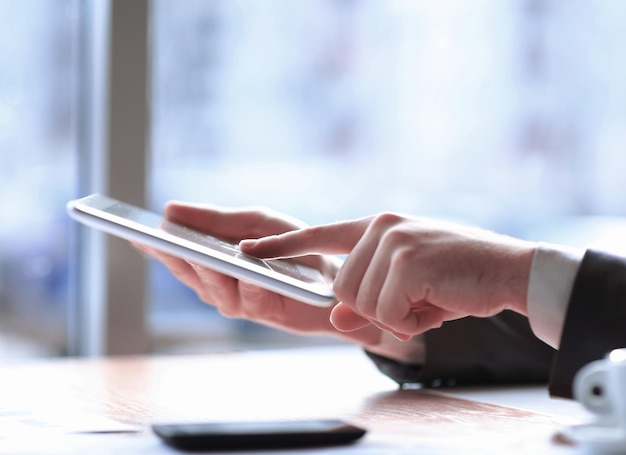 Close upbusinessman tapping the screen of the digital tablet