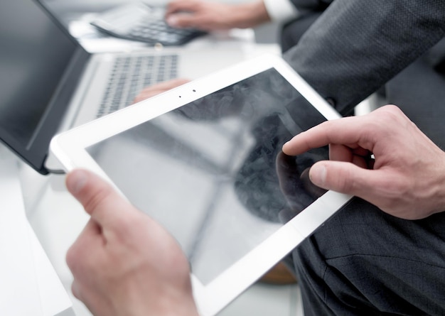 Close upbusinessman using digital tablet in office