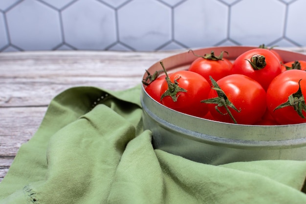 Close-updetail van een reeks kersentomaten in een metaalcontainer met groene doek