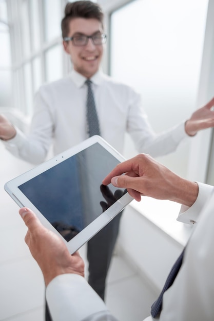 Close upemployees discuss standing in the hallway of the office