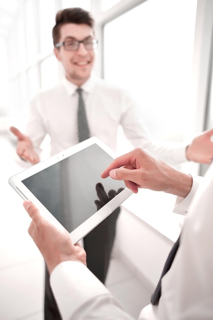 Close upemployees discuss standing in the hallway of the office