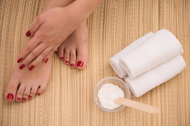 Close-upfoto van vrouwelijke voeten en handen bij kuuroordsalon op pedicure en manicureprocedure