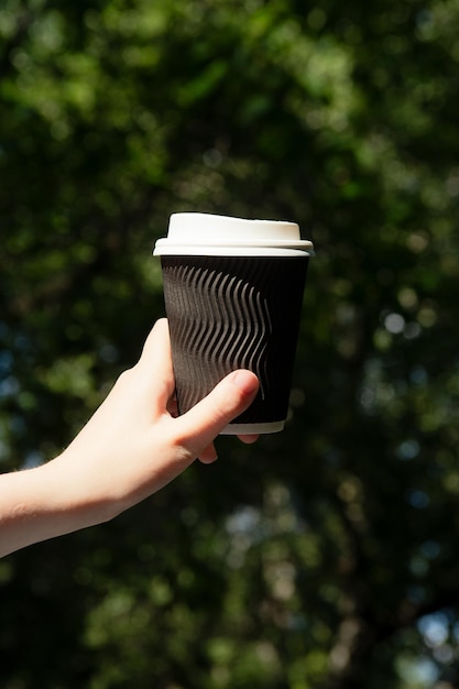 Close-upfotografie van een vrouw die een kopje koffie in de hand houdtPlaats voor logo