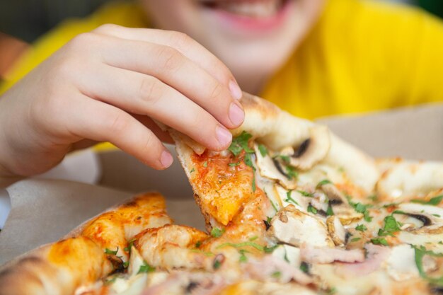 Close-upfotografie van kind dat stuk pizza eet