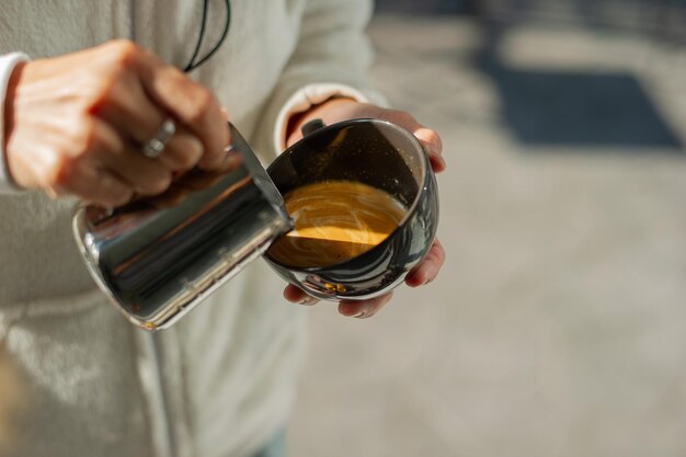 Close-uphand die hete latte art koffie doet