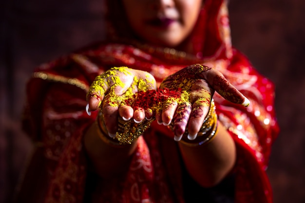 close-uphanden van het meisje die van India kleurrijk poeder in handen houden bij holifestival