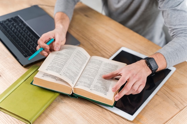 Foto close-upkerel die met woordenboek bestuderen