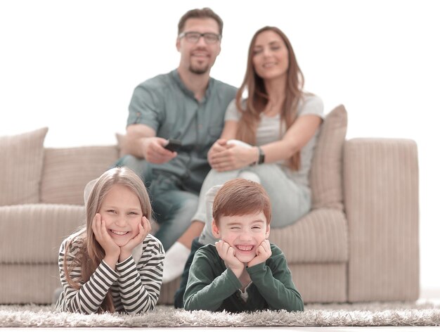 Close upkleine broer en zus liggend op het tapijt in de woonkamer