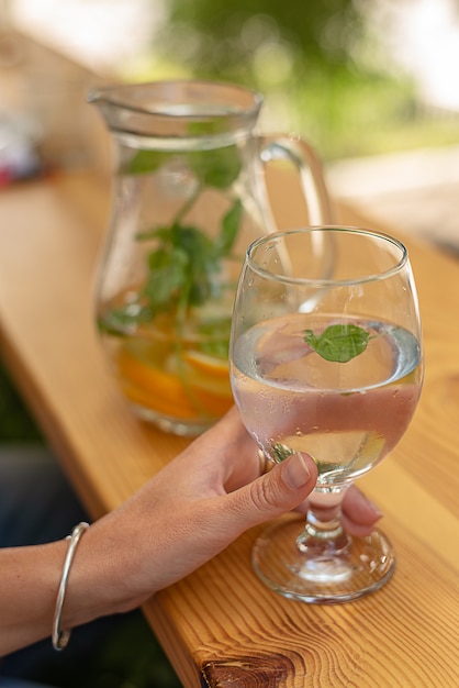 Close-upmening van glas water in vrouwelijke hand