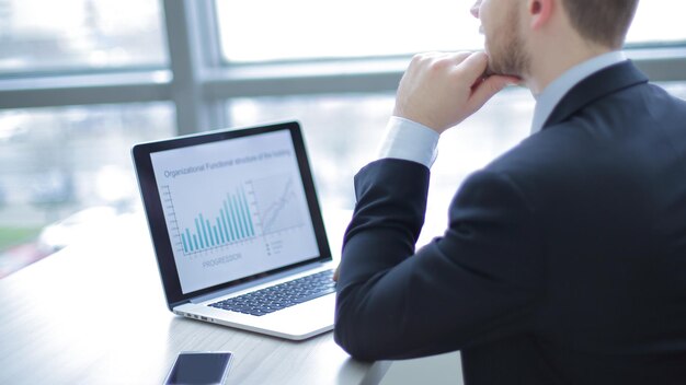 Close-upmoderne zakenman die op laptop in het bureau werkt