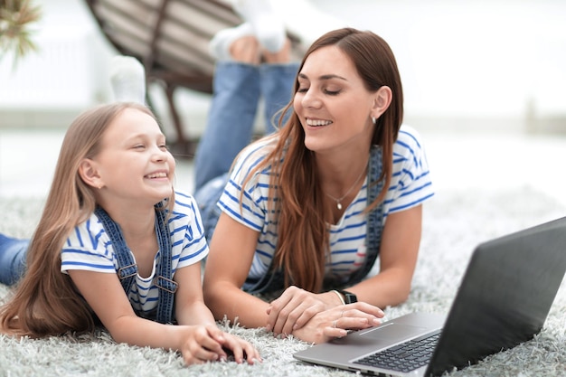 Close upmom and her little daughter playing on the laptop