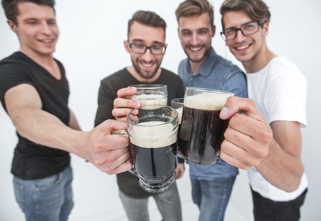 Close upmugs of beer in the hands of a group of men