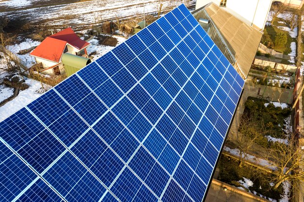 Close-upoppervlak van verlicht door zon blauw glanzend zonne-fotovoltaïsche panelen systeem op het bouwen van dak. hernieuwbare ecologische groene energieproductie concept.