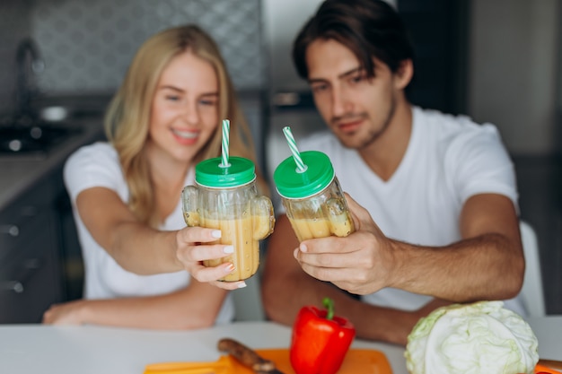 Close-uppaar die een glas met smoothies rasing. concept gezond voedsel.