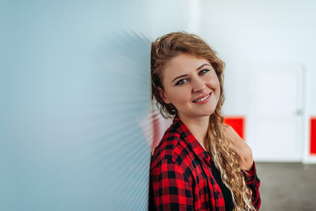 Close-upportret van een aantrekkelijke jonge aan een muur leunen en vrouw die in openlucht glimlachen.