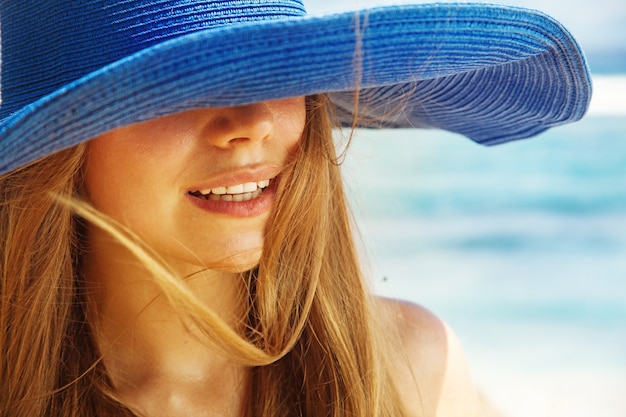 Close-upportret van een vrouw in een blauwe hoed die haar ogen bedekt