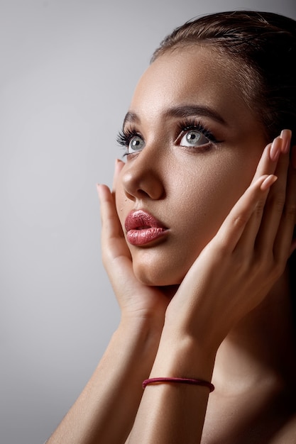 Close-upportret van het zuiverheidsgezicht van de mooie vrouw met volle lippen en grote blauwe ogen