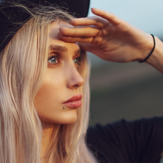 Close-upportret van jong blondemeisje met blauwe ogen die weg eruit zien.