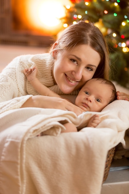 Close-upportret van moeder en babyjongen bij verfraaide ruimte voor Kerstmis