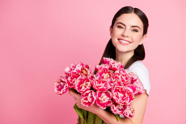 Close-upportret van vrij leuk meisje dat in handen bosfeestbloemen houdt?