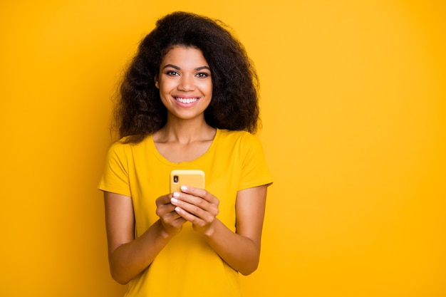 Close-upportret van vrolijk vrolijk zelfverzekerd meisje dat g gebruikt krijgt het verzenden van sms-bericht