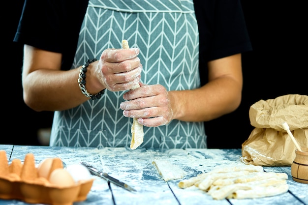 Close-upproces dat zelfgemaakte pasta maakt. Chef kok snijden met mes