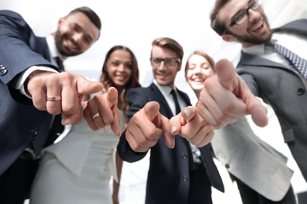 Close upsmiling business team pointing at you concept of success