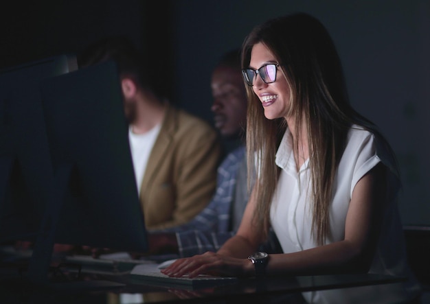 Close upsmiling business woman working on computerphoto on black background