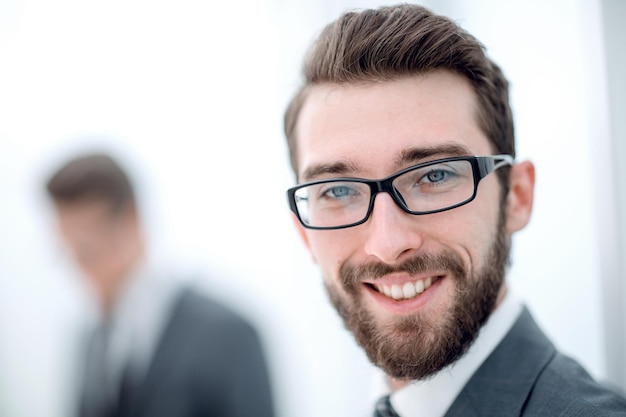 Close upsmiling businessman in the office background