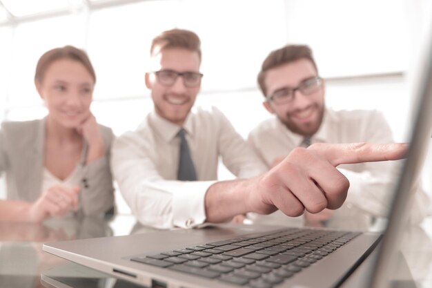 Close upsmiling businessman pointing at laptop screen