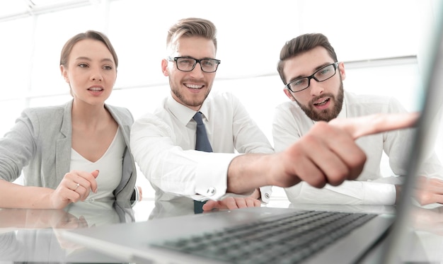 Uomo d'affari sorridente da vicino che punta allo schermo del computer portatile e alla tecnologia