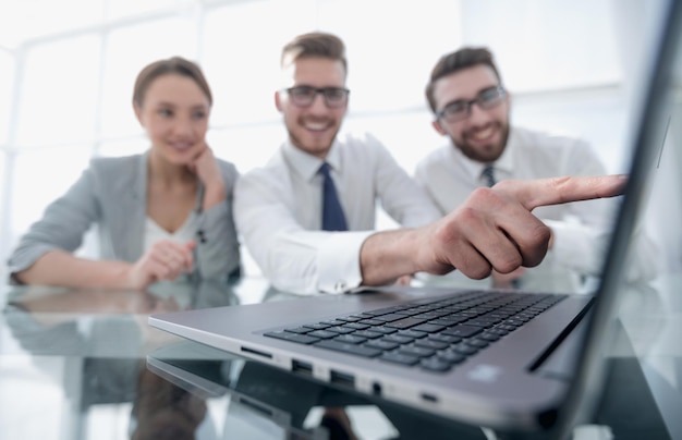 Close upsmiling businessman pointing at laptop screenbusiness and technology