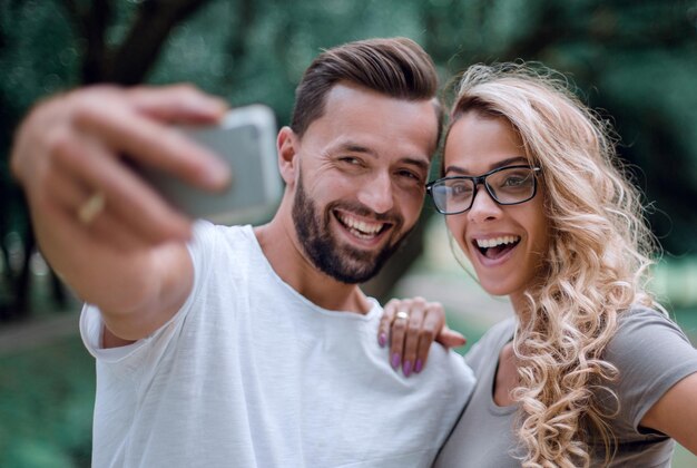 Close upsmiling young couple taking selfie in city Parkphoto for memory