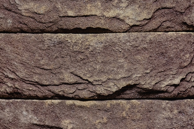 Close-uptextuur van een bruine bekraste baksteen met een opening