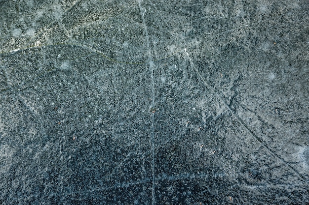 Close-uptextuur van gebarsten ijs op meerachtergrond