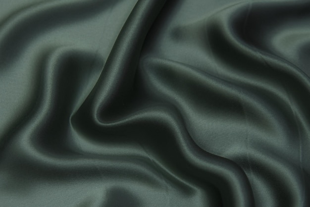 Close-uptextuur van natuurlijke groene stof of doek in dezelfde kleur. Stoffentextuur van natuurlijk katoen, zijde of wol, of linnen textielmateriaal. Groene canvasachtergrond.