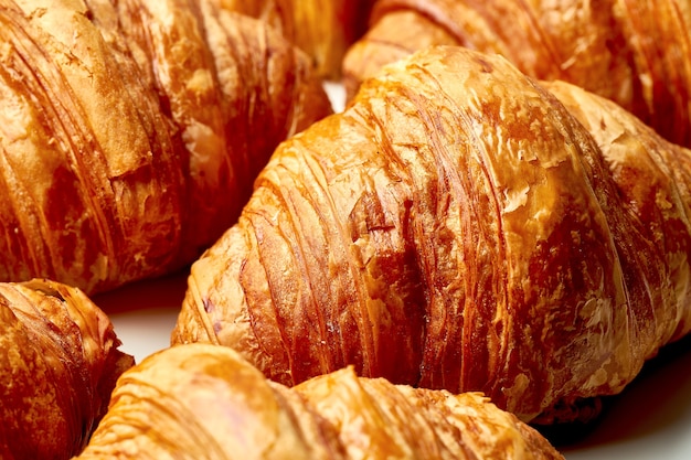 Close-uptextuur van versgebakken croissants op een witte achtergrond. Veel croissons-patroon