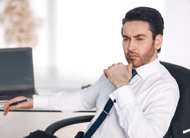 Close upthoughtful businessman sitting at his Desk