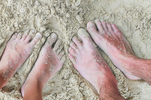 Close-upvoeten van een jong paar op wit zandstrand