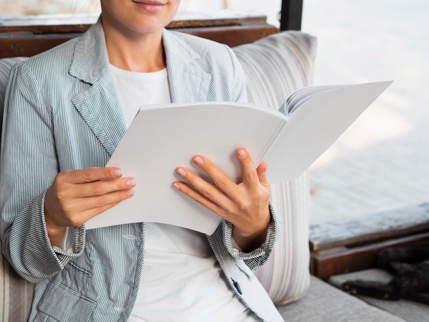 Foto close-upvrouw die een modeltijdschrift lezen