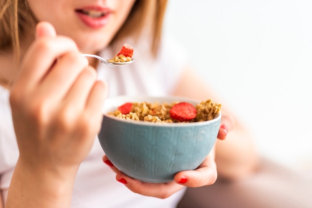 Close-upvrouw die kom graangewassen eten