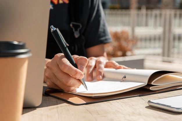 Foto close-upvrouw die op notitieboekje schrijft