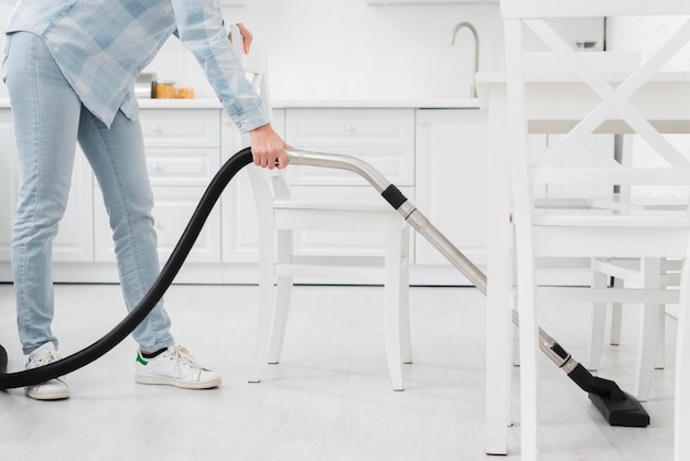 Close-upvrouw die schoon te maken vacuüm gebruiken