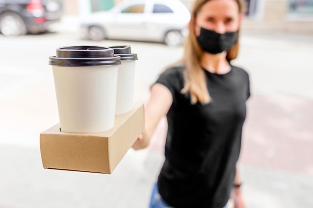 Foto close-upvrouw het leveren haalt koffie weg