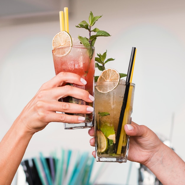 Close-upvrouwen die van cocktailglazen genieten